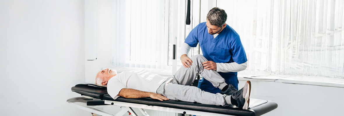 physiotherapist treating senior leg injury desktop