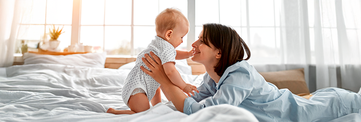 Young caregiver holding and caring for their newborn baby at home